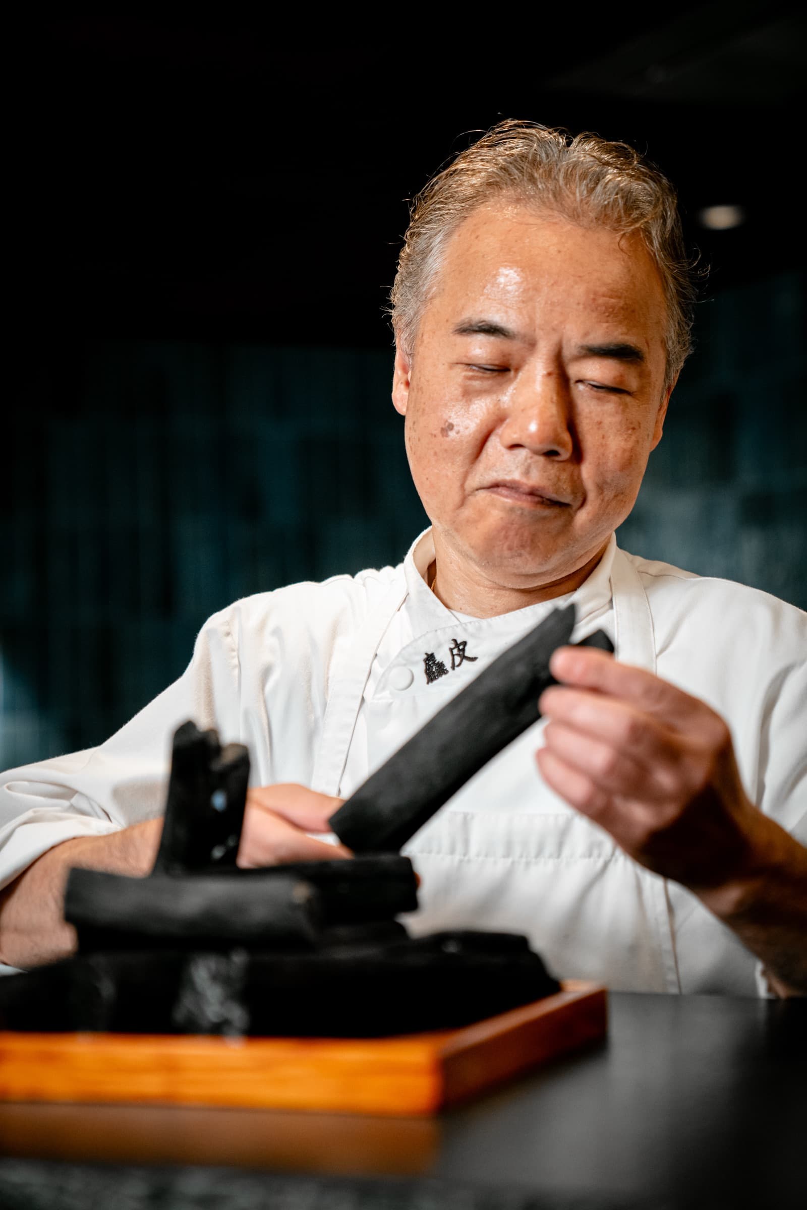 Chef preparing binchotan charcoal at Aragawa